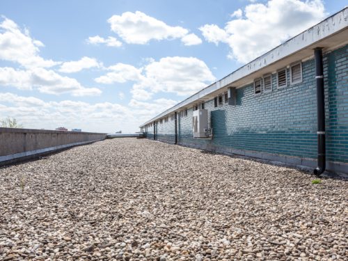 there are pebbles on the roof next to an stone wall